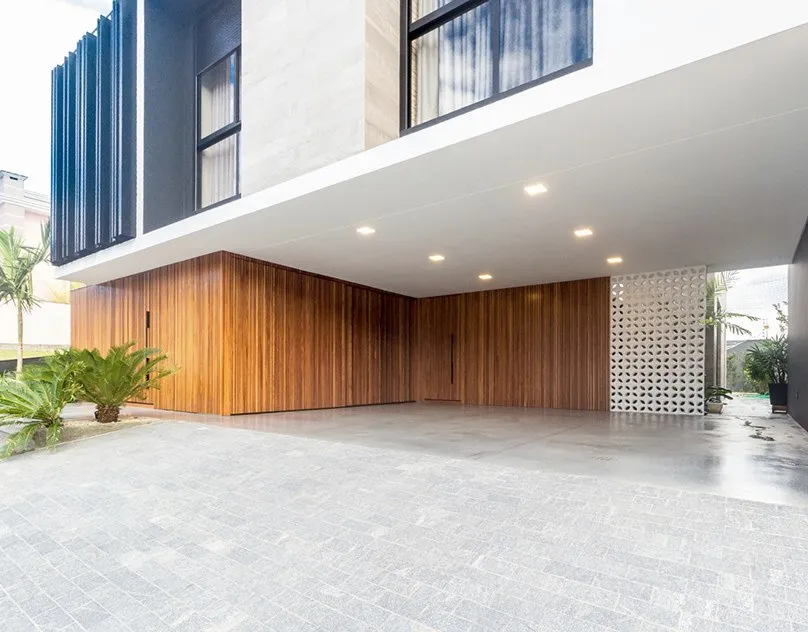 Garagem com parede de madeira e cobogó