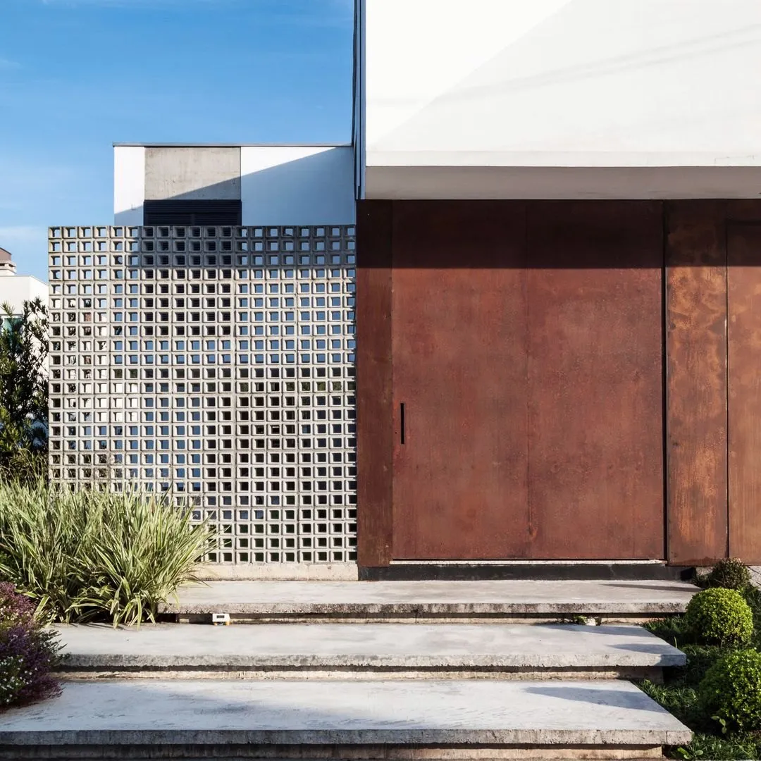 Entrada com cobogó e porta de aço corten