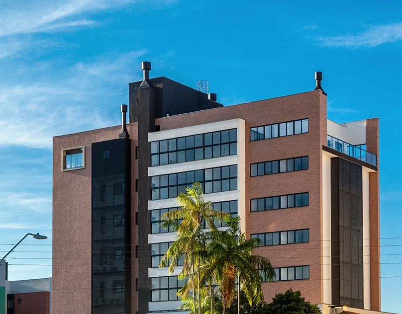 Edifício de tijolo aparente com palmeiras